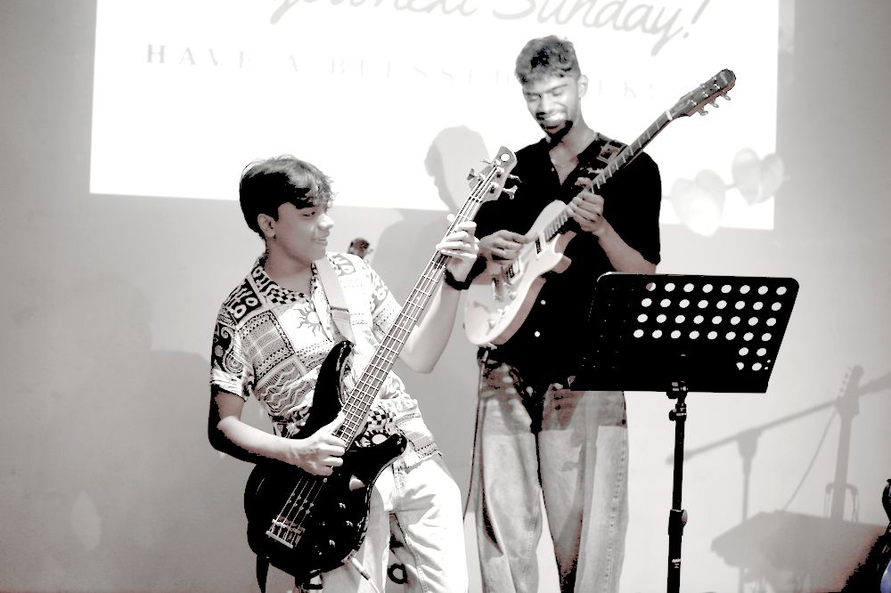 Bass and electric guitarists playing together on stage