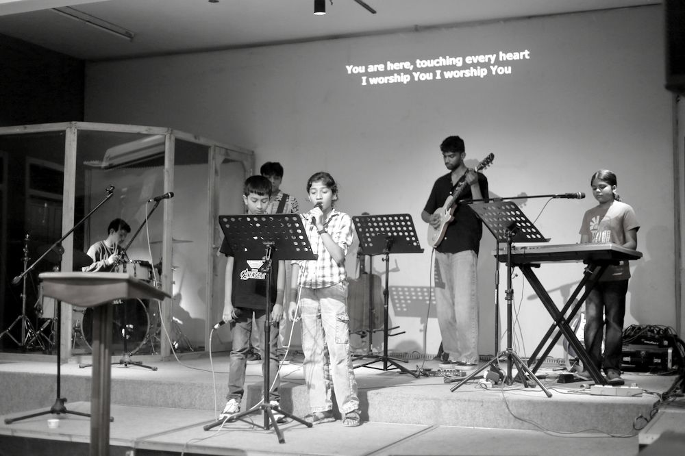 Children leading worship with the band