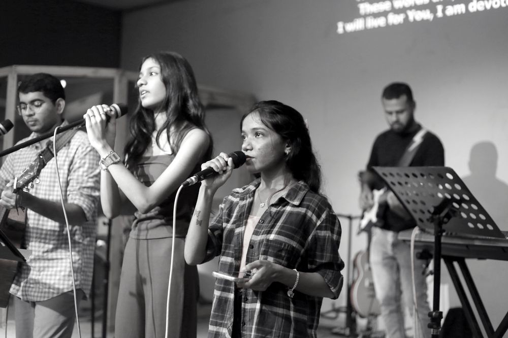 Vocalists leading worship with guitar and bass behind