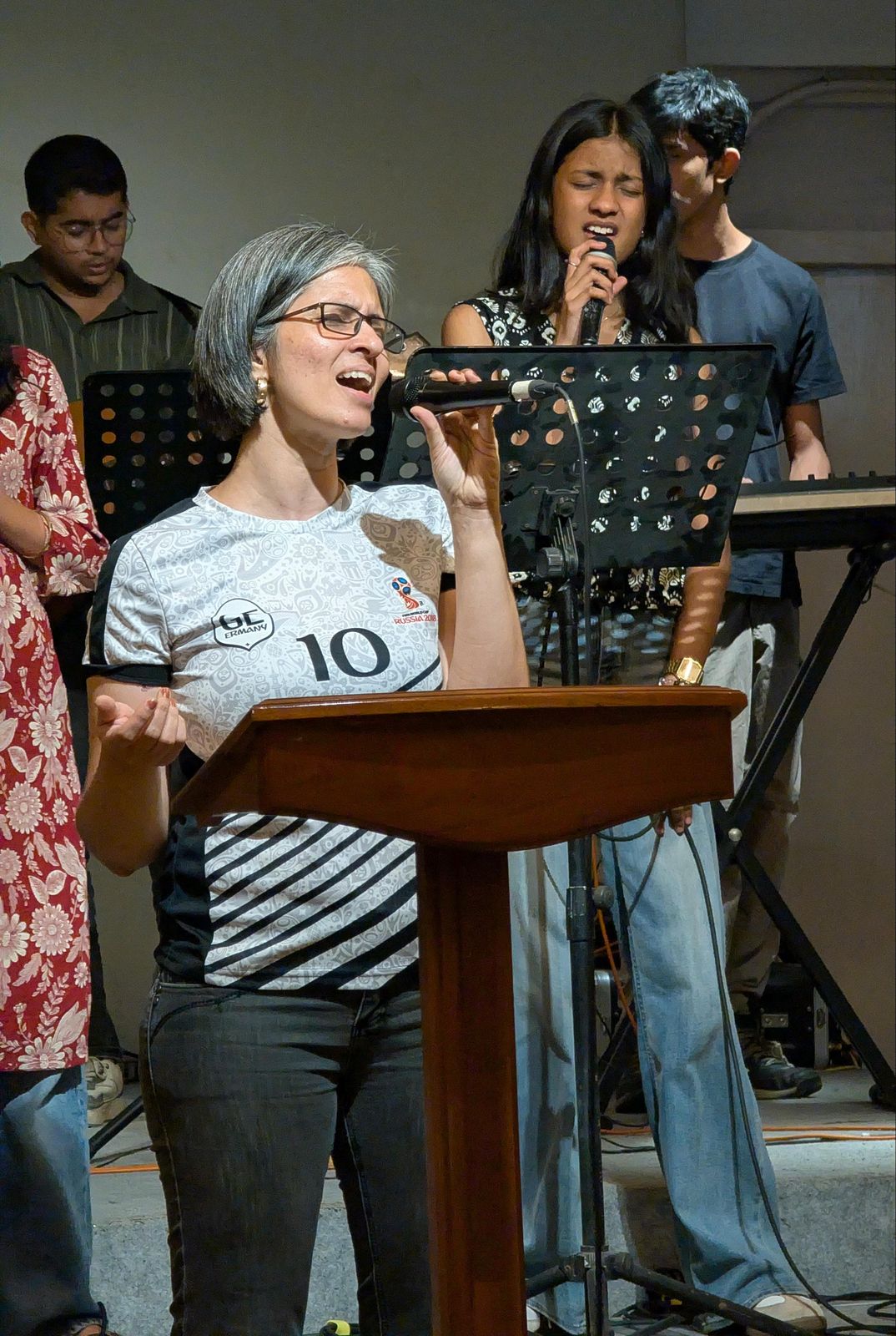 Worship leader singing at the front, with the band behind