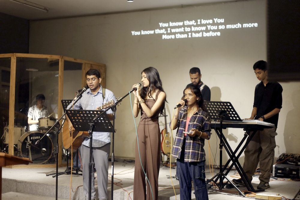 The full worship band on stage, with lyrics on the screen