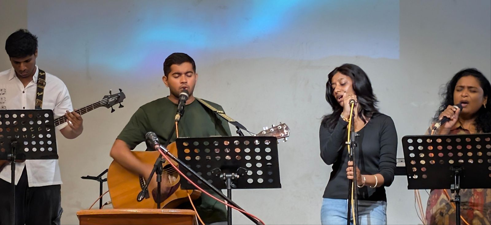 The worship team singing and playing guitar